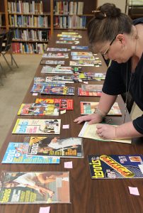 Academy Library Director Dr. Vandy Pacetti-Donelson inspects the tennis magazine collection that was recently donated to the American Sport Art Museum & Archives. 